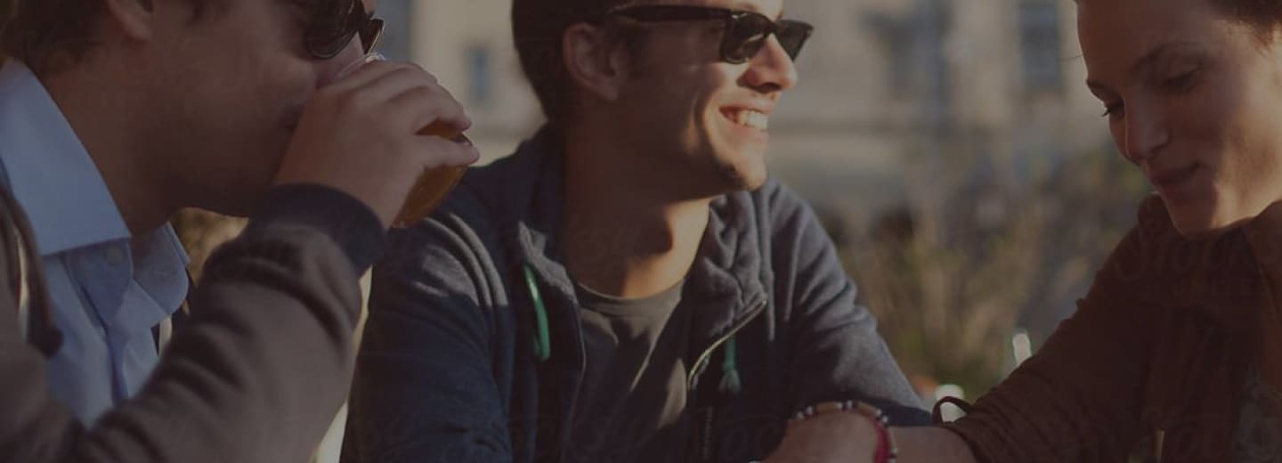 two men and a woman smiling in the sun